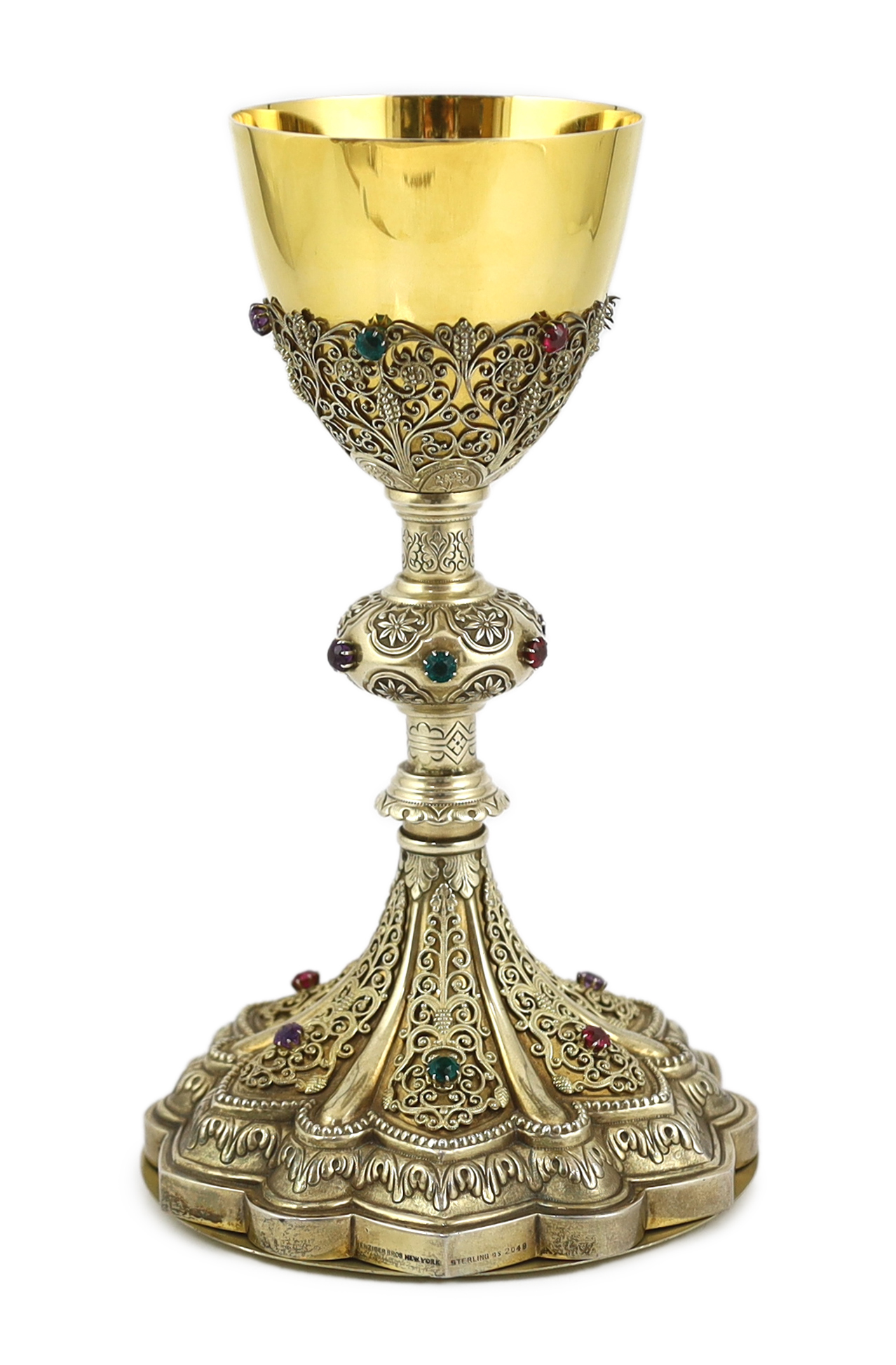 A late 19th/early 20th century American Eucharistic 14kt gold, silver gilt and multi coloured paste set chalice by Benziger Brothers, New York